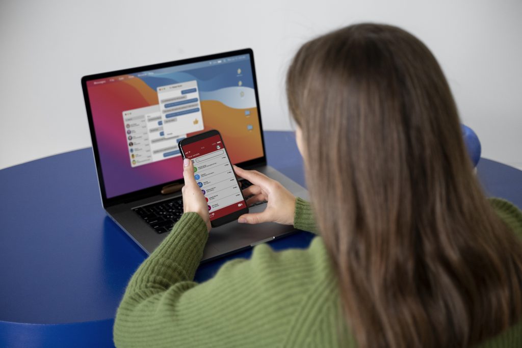 Jeune femme utilisant un smartphone et un ordinateur portable – Young woman using a smartphone and laptop